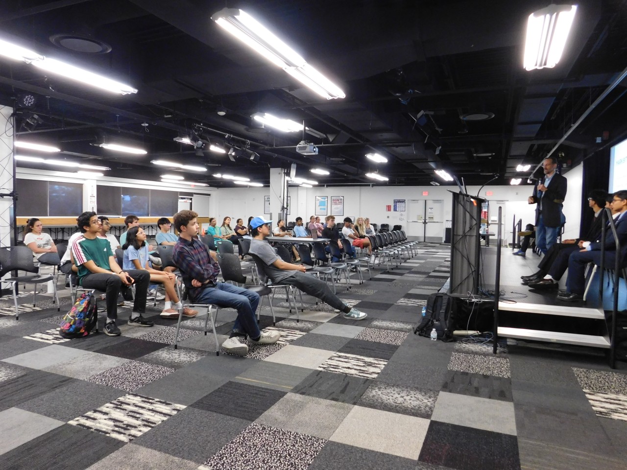 Students seated in a full room listening to a speaker at an ABLE workshop